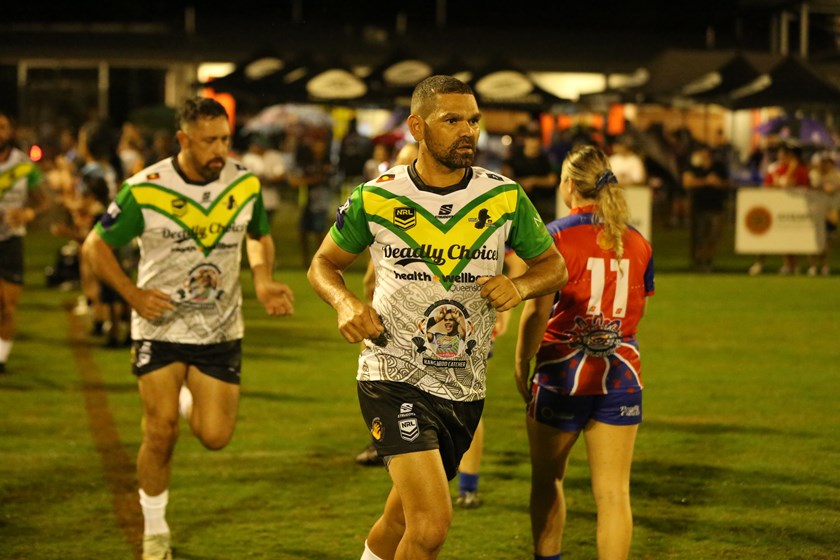 Michael Purcell Memorial captain Wes Conlon runs out with the image of Michael Purcell in his famous kangaroo pose. Photo: Jacob Grams/QRL