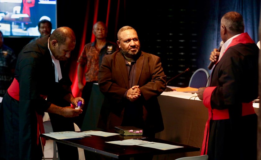 PNGRFL chairman Sandis Tsaka being sworn in by DCM Mr Mark Selefkairu and Magistrate Mr Clivson Philip. Photo: PNGRFL Media