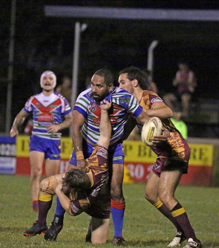 Innisfail's Fred Koraba refused to be brought down in a tackle despite the attention of Suburbs players Ricky Macri and Minjiluk McInnes. Photo: Maria Girgenti