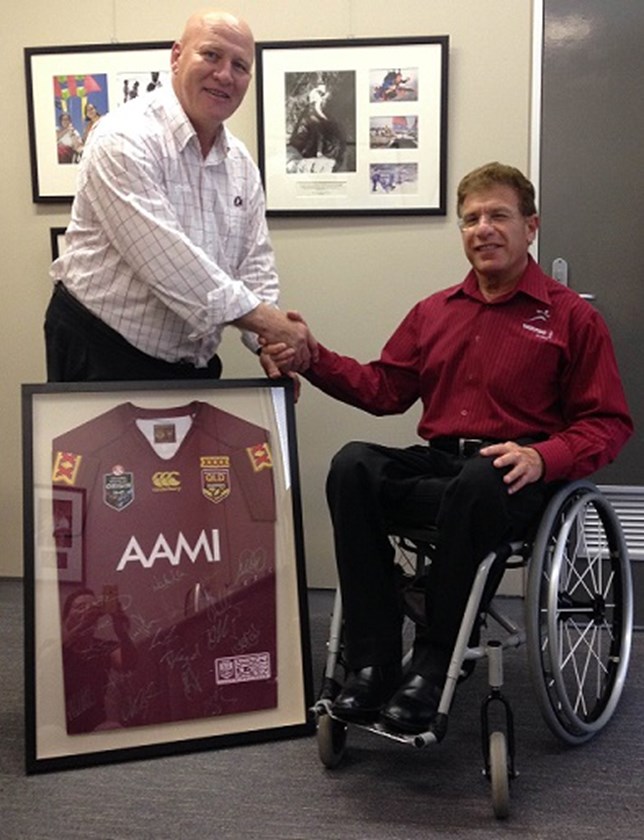 Shane McNally as Rugby League Brisbane manager in 2015, presents a donation of a framed 2014 Queensland Maroons jersey to Sporting Wheelies and Disabled Association CEO Ray Epstein.