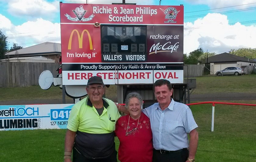 Richie Phillips, Jean Phillips and major sponsor, Keith Beer in front of the Richie and Jean Phillips scoreboard. 
