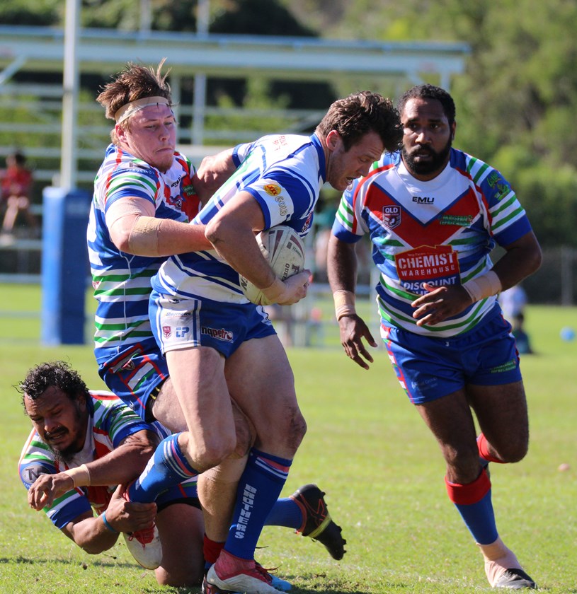 Cairns Brothers player Joe Eichner is stopped in his tracks by Innisfail's Jaymon Moore and Dan Sagigi Photo: Maria Girgenti