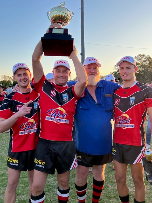 Peter Bourchier holds the trophy alongside coach Locky Prior and sons Jack and Bill.
