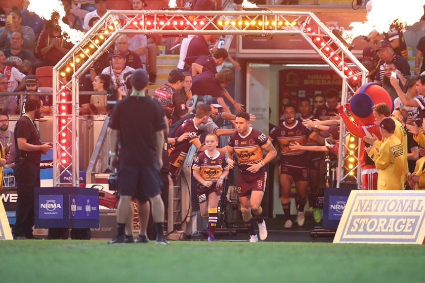 Charli Berghauser running out with Brisbane Broncos captain Darius Boyd. Photo: NRL Images